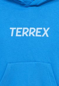 Sweat à capuche bleu vif avec une poche avant et le mot "TERREX" imprimé en lettres blanches en gras sur la poitrine.