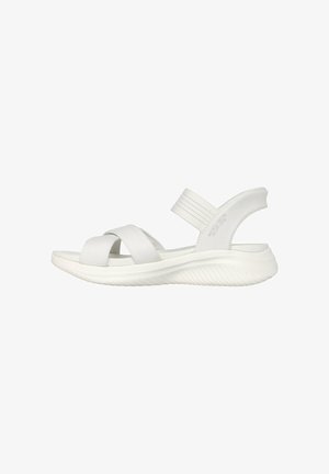 White open-toe sandal with crisscross fabric straps, padded sole, and elastic back strap against a white background.