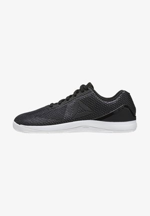 Zapatilla atlética negra de malla con suela blanca, cordones y logo triangular en el lateral, vista desde el lado exterior.