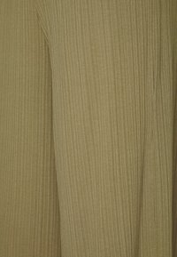 Tissu vert olive avec une texture côtelée verticale. Le matériau semble léger et doux, affichant une légère brillance et une finition lisse.