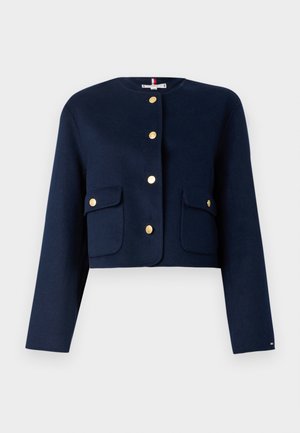 Navy wool crop jacket with long sleeves, gold buttons, and two front patch pockets. Features a round neckline and clean lines.