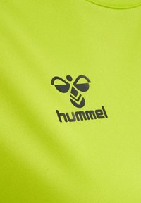 Geel stof met zwart gestileerd hommel-logo en de tekst "hummel" gedrukt op het oppervlak van het materiaal.