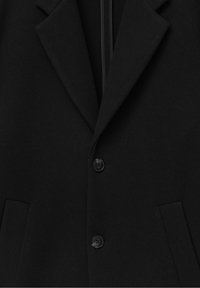 Blazer in misto lana nera con rever a punta, due bottoni e tasche laterali. La texture è liscia con un taglio sartoriale.