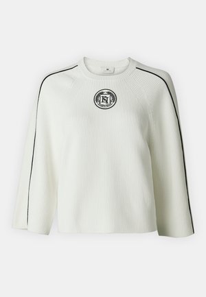 Maglione bianco a costine con strisce nere laterali e un logo ricamato circolare sul petto, con scollo a girocollo e maniche larghe.