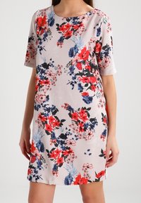 Květinové šaty s krátkým rukávem. Mají světlé pozadí s červenými, modrými a černými květinovými vzory. Měkká látka, kulatý výstřih.