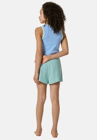 Débardeur rayé bleu avec bordures bleu clair associé à un short vert menthe. Le tissu semble léger, le short présente une coupe décontractée et une texture lisse.