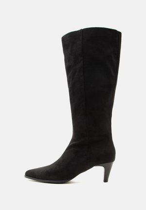 Schwarzer kniehoher Wildlederstiefel mit spitzer Schuhspitze und mittelhohem schlankem Absatz auf weißem Hintergrund.