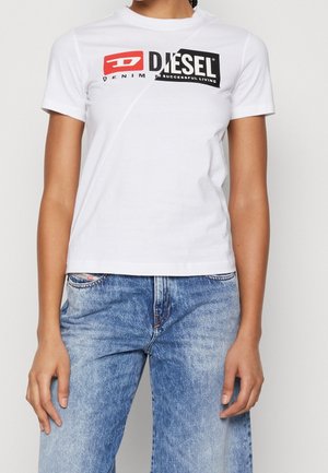 Biały bawełniany t-shirt z krótkimi rękawami, ozdobiony wyraźnym czarno-czerwonym logo graficznym. W połączeniu z jasnoniebieskimi dżinsami o jasnym praniu.