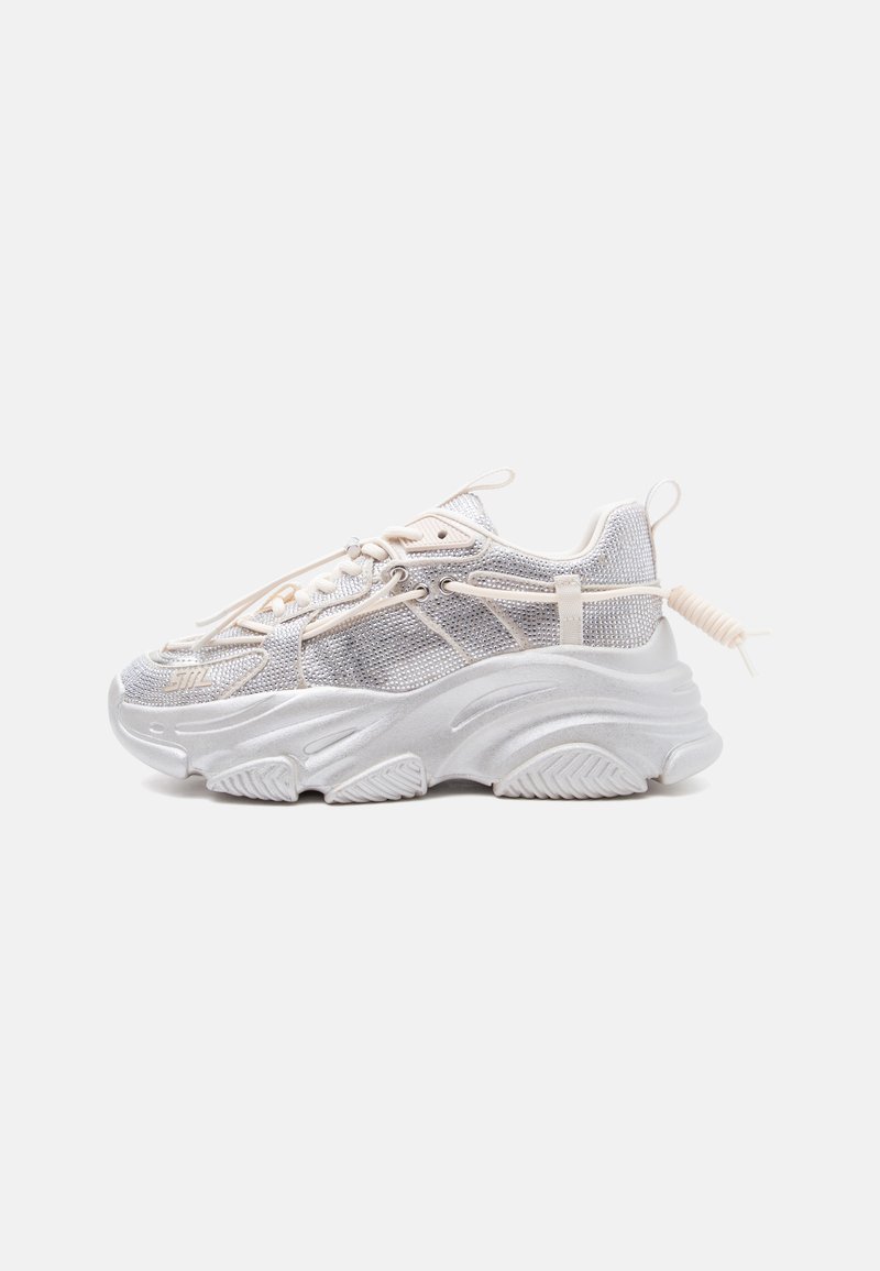 Χοντρό λευκό αθλητικό παπούτσι με πλέγμα πάνελ, παχύ ανάγλυφο σόλα, ελαστικά κορδόνια με θηλιά και θηλιά στο πίσω μέρος, εμφανίζεται σε πλαϊνή όψη.