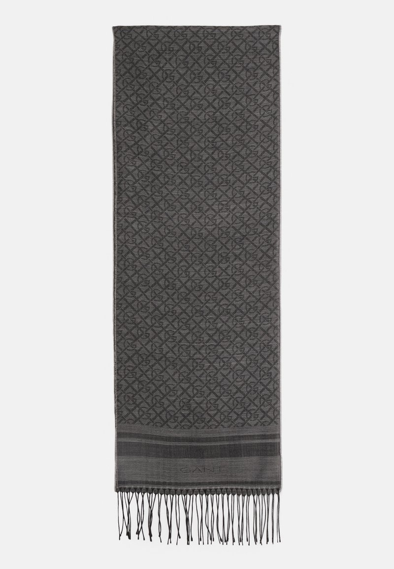 Dark gray rectangular scarf with a subtle geometric pattern, fringed ends, and a tonal brand name near one fringe edge.