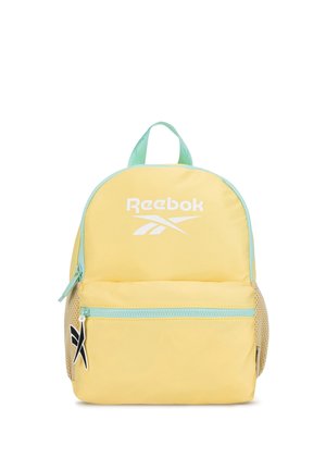 Żółty plecak Reebok z jasnoniebieskim suwakiem i uchwytem, przednią kieszenią na zamek, siateczkowymi kieszeniami po bokach oraz logo Reebok na przednim panelu.