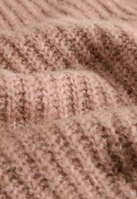 Ţesătură tricotată de culoare roz pudrată, cu textură nervurată şi fibre vizibile. Uşoară şi flexibilă, ideală pentru haine confortabile.