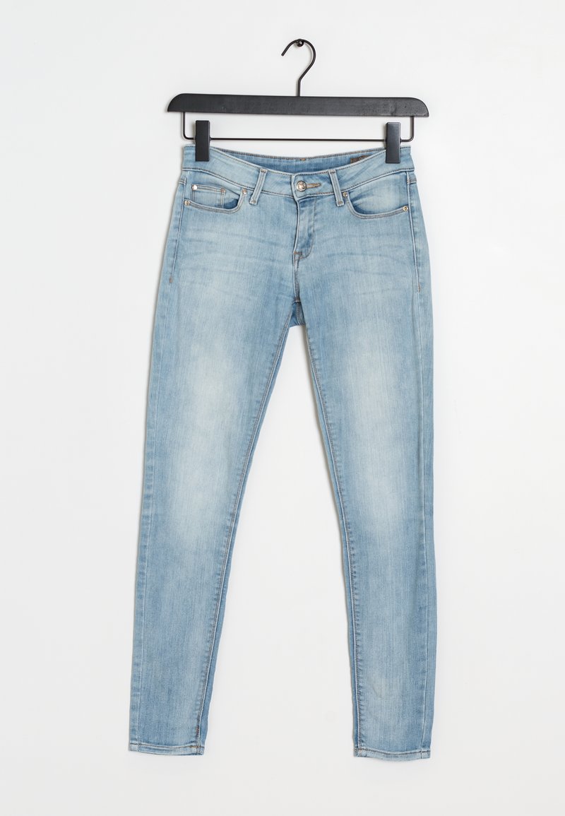 Jeans skinny de mezclilla azul claro con un diseño estándar de cinco bolsillos. La tela tiene una textura suave y ligeramente desgastada. Cuenta con un cierre de botón y cremallera.