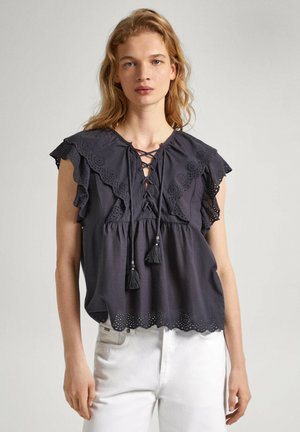 Blusa grigia scura con maniche a volant, scollatura a lacci e dettagli con nappine. Presenta un particolare in broderie anglaise all'orlo per aggiungere texture e design.