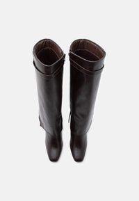 Brązowe skórzane kozaki za kolano z zaokrąglonym noskiem, wysokimi cholewami i bocznymi zamkami błyskawicznymi. Gładka tekstura z minimalnymi detalami na powierzchni.