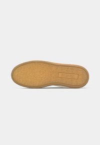 Shoe bottom with a textured rubber sole in beige, featuring a slightly curved edge and a clear label embossed with "plaiter."