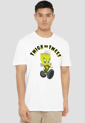 Young man wearing white t-shirt with cartoon yellow bird dressed as Frankenstein and "Twick or Tweet" text above it.