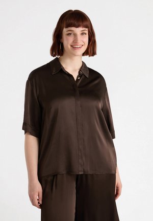 Camisa corta de satén marrón con cuello y cierre frontal de botones. Textura suave y corte holgado.