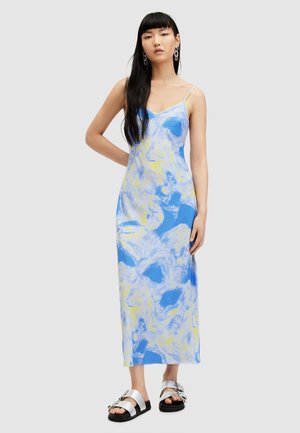 Rochie maxi cu un model de marmură albastru și galben, cu bretele subțiri, realizată dintr-un material neted, asortată cu sandale cu accente argintii.