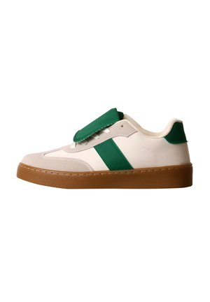 Baskets blanches avec des accents verts et une semelle marron, avec un grand rabat vert couvrant les lacets sur fond blanc.