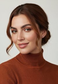 Brun ribbad polotröja med hög krage och slät textur. Modellen har stylat hår och små, färgglada örhängen.