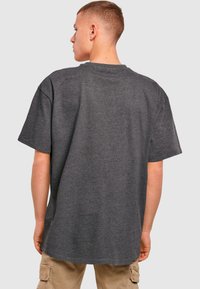 Grå kortærmet t-shirt med rund hals, afslappet pasform og blød tekstur. Synlige sydetaljer langs halsudskæringen og skuldrene.