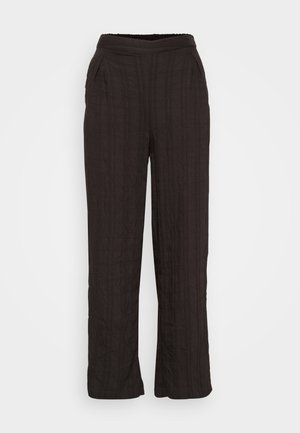 Pantalones anchos negros hechos de una tela texturizada con un diseño plisado. Presentan una cinturilla elástica y bolsillos laterales.