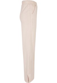 Lyserøde joggebukser med elastisk midjebånd, sidelommer og rett ben-design. Mykt, glatt stoff med en subtil tekstur.