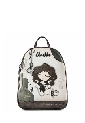 Zaino con una ragazza dei cartoni animati che dirige la musica, schizzi di violino e sassofono, e il testo "Anekke" e "Be with sound" su sfondo crema e marrone.