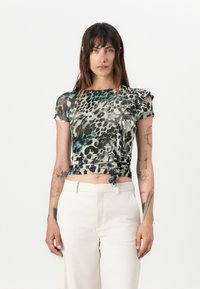 Top scurt cu maneci, ajustat, cu un model de leopard care prezintă nuanțe de verde și bej; detaliu strâns pe lateral cu un șnur.