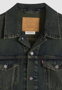 Τζιν μπουφάν σε σκούρο πράσινο, με κλασικό γιακά, κουμπιά στο μπροστινό μέρος, δύο τσέπες στο στήθος και δερμάτινη ετικέτα με λεπτομέρειες της μάρκας.