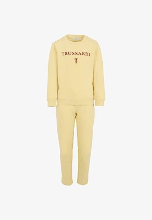 Żółty zestaw z dresu w skład którego wchodzą bluza i spodnie, z napisem "TRUSSARDI" w kolorze bordowym z przodu. Miękki materiał z ściągaczami przy mankietach i u dołu. Prosty design.