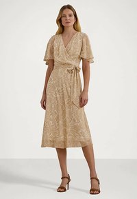 Μπεζ floral φόρεμα ριχτό με κοντά, αέρινα μανίκια, ζώνη στη μέση και ρο flowing σιλουέτα, που διαθέτει μαλακή υφή και σχέδιο μέχρι το γόνατο.