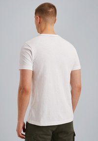 T-shirt blanc à manches courtes en tissu doux, avec un col rond, une texture lisse et une coupe décontractée, vu de dos.