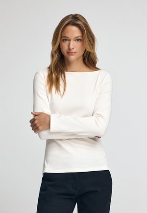 Długi rękaw, prążkowany top w off-white z szerokim dekoltem. Gładka tekstura, dopasowany krój i subtelny detal z logo na rękawie.