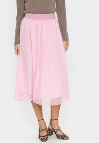 Gonna midi rosa chiaro con vita elasticizzata e strati di tessuto trasparente. Abbinata a scarpe con tacco alla caviglia in stampa leopardata marrone e nera.