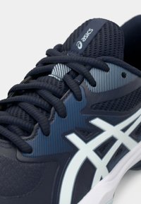 Αθλητικό παπούτσι σε ναυτικό μπλε με επάνω μέρος από δίχτυ, αντιθετικές λεπτομέρειες σε ανοιχτό μπλε, υφή στην επιφάνεια και παραδοσιακό κλείσιμο με κορδόνια.