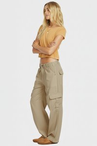 Beige cargo pants with multiple pockets and a loose fit, paired with a mustard cropped t-shirt and brown flat-soled shoes.