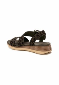 Sandalias con estampado de leopardo y correas en verde oscuro, con una suela texturizada y un tacón apilado de color marrón claro. Hebilla ajustable en el lateral.