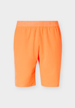 Élénk narancssárga, térdig érő rövidnadrág, elasztikus derékpánttal, finom dombornyomott márkajelzéssel, egyszínű háttér előtt bemutatva.