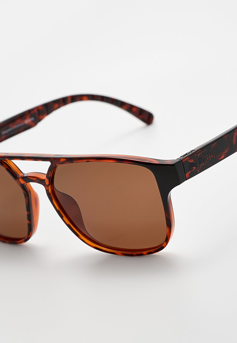 Okulary przeciwsłoneczne w kolorze tortoiseshell z brązowymi szkłami; czarne ramiona z teksturowanym wzorem; prostokątny kształt; elegancki design.