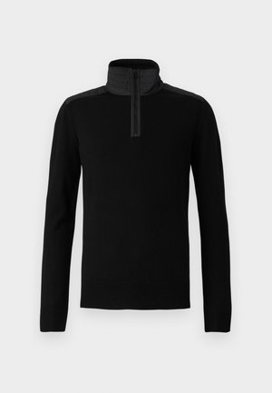 Sudadera negra con un cuello alto y cierre de media cremallera. Presenta una tela suave y paneles de hombros texturizados en contraste.