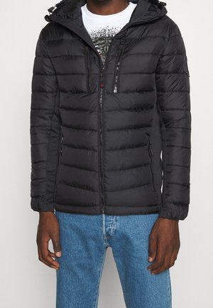 Doudoune noire avec fermeture éclair, capuche et deux poches avant zippées. Présente des panneaux cousus et des poignes élastiques pour un ajustement optimal.