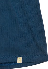 Donkerblauw ribstof met een zachte textuur, voorzien van een gele label met een gestileerd logo aan de zoom.