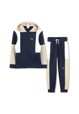 Marineblauwe en beige hoodie met witte accenten, rits aan de voorkant en zakken, gecombineerd met bijpassende broek met een elastische tailleband en logodetail.