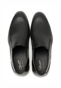 Scarpe slip-on nere con un design textured e intrecciato, dettagli in pelle liscia e una soletta imbottita per il massimo comfort.