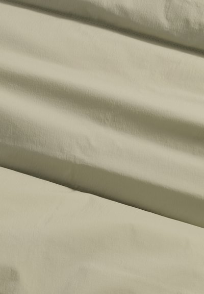 Lys beige stof med en blød, let krøllet tekstur, der har subtile variationer i nuancerne og en glat overflade.