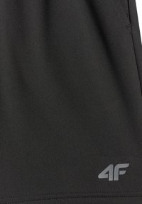 Tissu noir texturé avec un petit logo gris "4F" près du bord inférieur, probablement une partie de vêtements de sport ou décontractés.