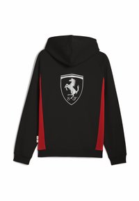 Sort hættetrøje med røde sidepaneler, der har et stort sølv Ferrari-logo på ryggen; lavet af blødt, glat stof.