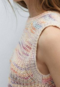 Strickoberteil ohne Ärmel in Pastellfarben mit einem strukturierten Muster. Verfügt über weite Armausschnitte und einen runden Ausschnitt, der ein weiches Garn zur Geltung bringt.